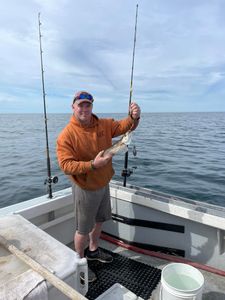 A fisherman standing next to a catch in Gloucester