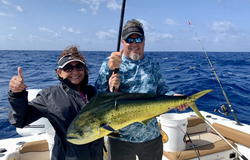 Two anglers stand in Islamorada, holding a 28-inch fish