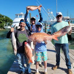 Successful fishing trip in Islamorada FL with mutton snapper and king mackerel catch displayed on marina dock