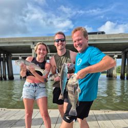 Three redfish, black drum, and black drum caught by three people fishing at Hilton Head Island