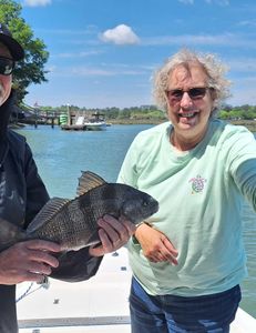 Proud angler holding a 15-inch Black Drum fish from Hilton Head Island