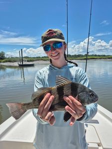 A fisherman holding a large black drum fish on Hilton Head Island