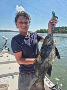 A fisherman holding a big black drum fish on Hilton Head Island