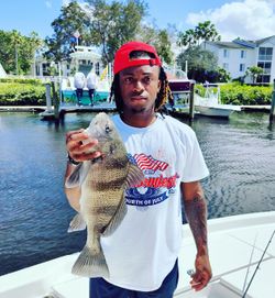 A fisherman holding a 17-inch black drum fish in Fort Pierce