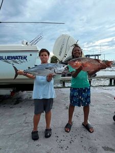 Two anglers displaying their catch of Little Tunny and snapper after fishing trip in Fort Pierce FL