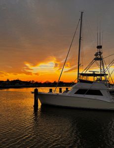 White fishing boat docked at marina during golden sunset in Norfolk VA