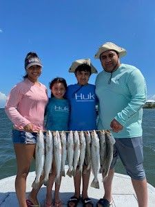 A group of 4 people fishing on the beach at South Padre Island