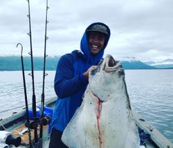 Fisherman holding a Pacific Halibut in Larsen Bay