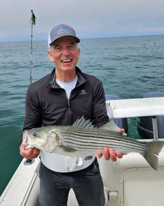 Fisherman with a striped bass caught in MA