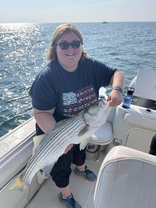Reeling in a 17-inch striped bass on a partly cloudy day!