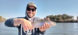 Angler catching a rainbow trout in Anderson