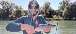 Angler catching a rainbow trout in Anderson