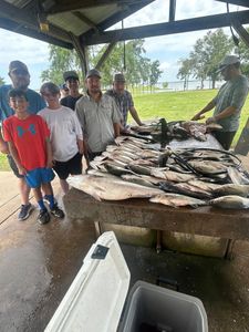 Group of 7 people enjoying outdoor fishing and hunting activities in OK location.