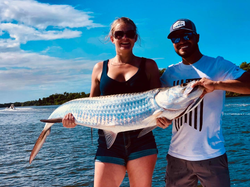 A pair of anglers reeling in a big fish in San Juan