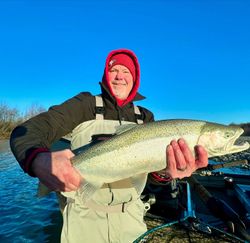 Photograph of a fisherman holding a pink salmon in Oregon