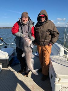 Two people fishing with a big 26-inch catch near Cross location