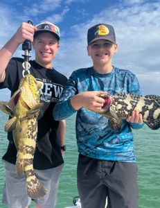 Two anglers reeling in their catch while enjoying a fishing tour in FL