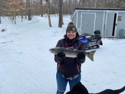 Angler reeling in a rainbow trout in Maine