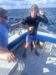 The angler battles a mystery catch with their heavy tackle in the choppy waters off West Palm Beach.
