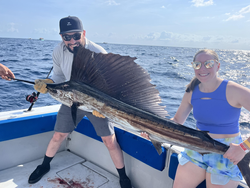 Reeling in a big one on a perfect day at sea.