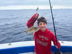 An angler catches a white grunt fish in West Palm Beach
