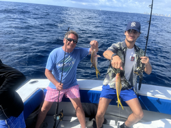 Reeling in a pair of yellowfin tuna with a mix of fishing tactics on a partly cloudy day.
