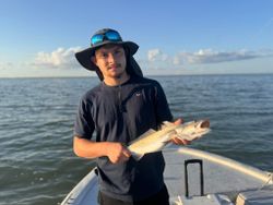 Angler holding caught fish on fishing boat in Rockport TX waters