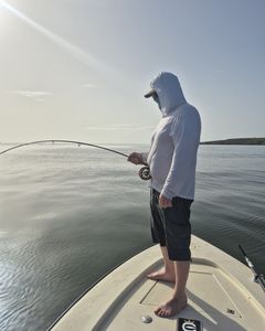 Angler with bent fishing rod fighting fish from boat deck in Dorado PR waters