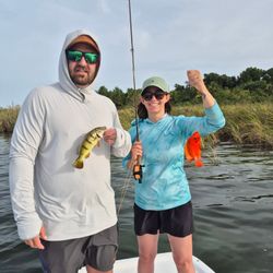 Two anglers displaying freshly caught peacock bass and colorful fish on fishing boat in Dorado PR waters
