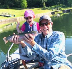 Angler holding a rainbow trout fish in an unknown location