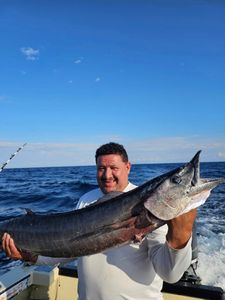 Fisherman holding a large wahoo fish in Sneads Ferry