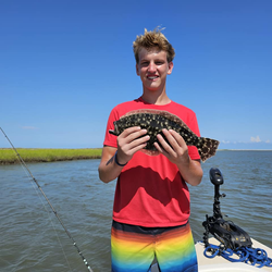 A fisherman holding a 15-inch southern flounder in South Carolina