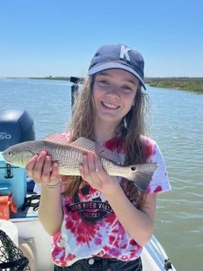 Angler catching a 15-inch redfish at Folly Beach