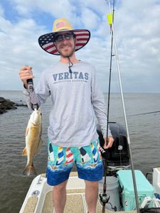 Angler holding caught redfish on fishing boat in Spanish Fort AL waters