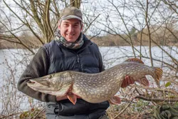 Angler holding a large northern pike fish catch in MA
