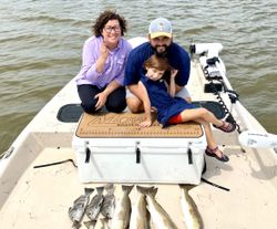 Three people fishing at Matagorda with boats in the background
