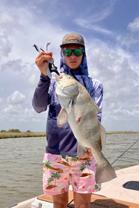 A person fishing for a black drum in TX
