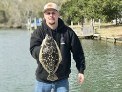 A fisherman holding a summer flounder catch in Cedar Point