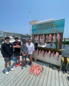 3 fishing rods held by 5 people in Destin