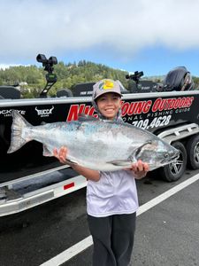 A fisherman holding a Chinook Salmon in Gold Beach