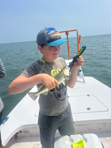 A lone angler braves the elements with their deep sea jigging setup, hoping to reel in the catch of the day.