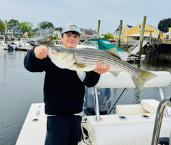 A huge striped bass reeled in with fancy fly fishing moves!
