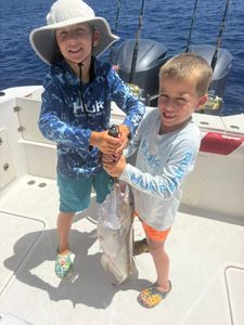 Two young anglers holding freshly caught fish on fishing boat deck in Little Torch Key FL