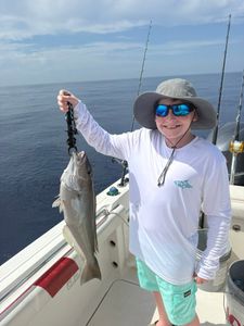 Fishing catch held up on boat in Little Torch Key FL waters with fishing rods in background