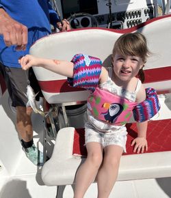 Child displaying caught Southern Kingcroaker fish on boat in Little Torch Key FL