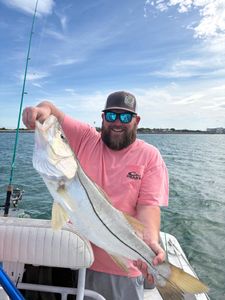 Angler holding large snook fish on fishing boat in Port Canaveral FL waters