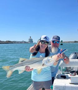 Snook caught fishing in Port Canaveral FL waters with boat and cruise ship in background