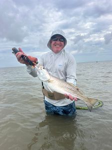 Angler holding a fishing rod on the shore in TX