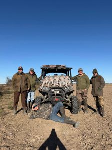 Hunting group with harvested birds loaded on ATV in Matagorda TX field