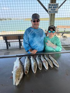 Fresh caught redfish and speckled trout displayed on fish cleaning table at Matagorda TX fishing dock